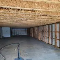 Spray foam insulation applied along the roof and walls of a large building